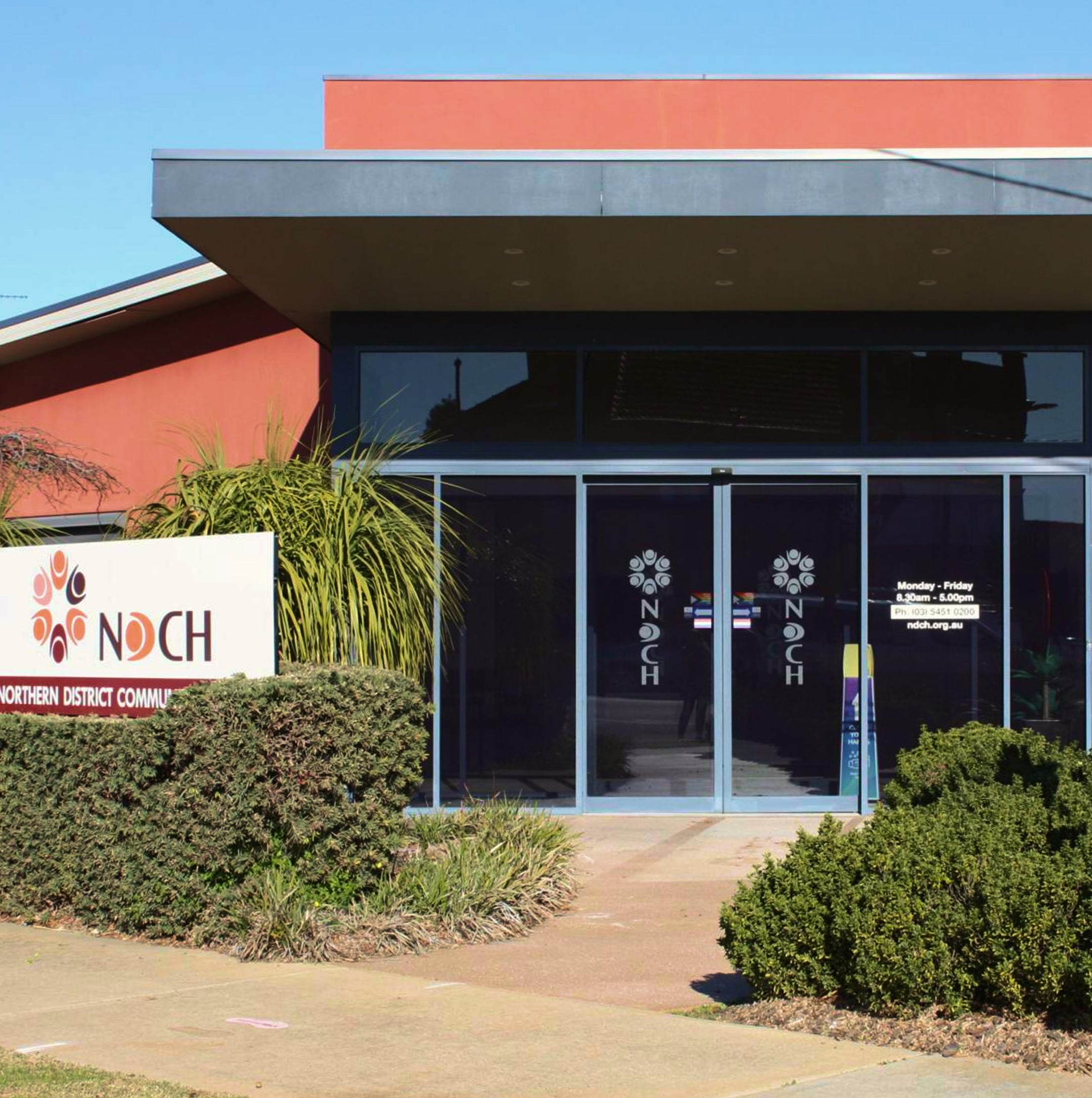 A modern building with glass doors and a sign reading NDCH Northern District Community Health