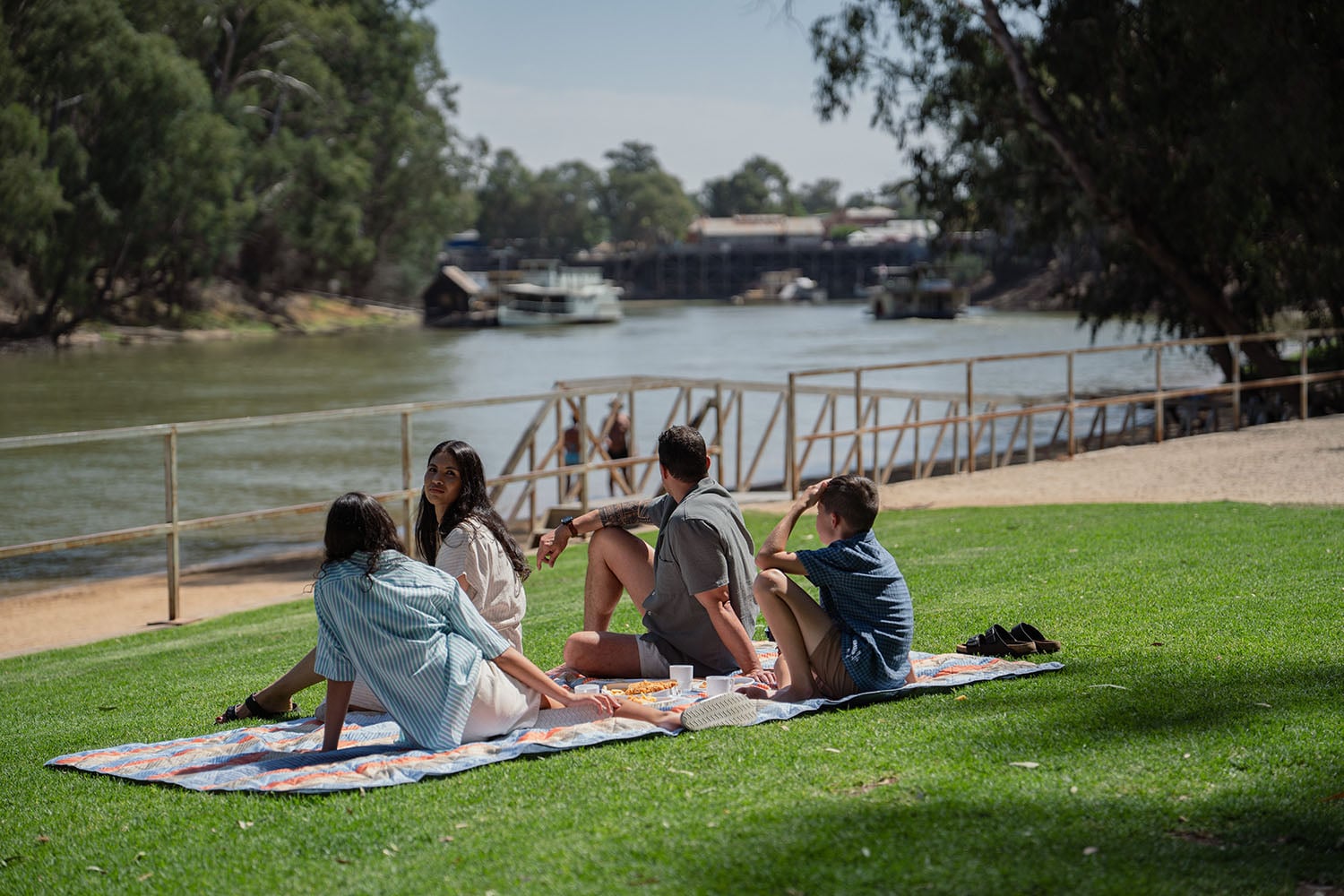 Four people having a picnic by a river in the picturesque Loddon-Mallee Region.