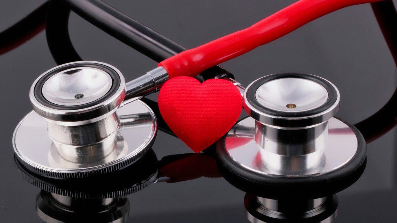 Two stethoscopes with a small red heart between them